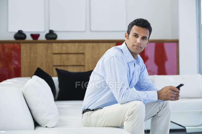 Businessman sitting on sofa at modern office — Stock Photo