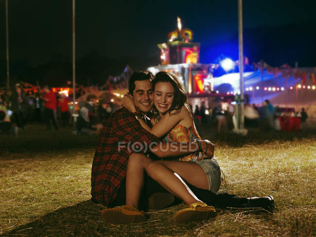 Happy couple hugging outside music festival — Stock Photo