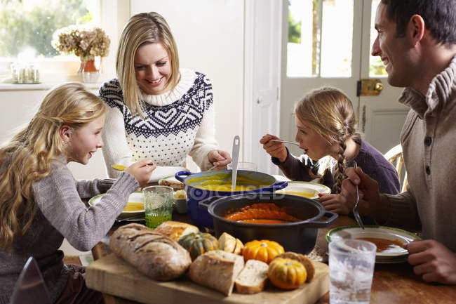 Glückliche Familie beim gemeinsamen Essen am Tisch — Stockfoto