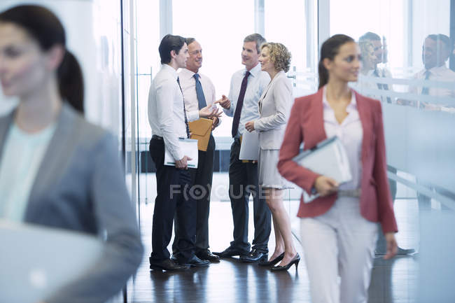 Geschäftsleute unterhalten sich im Flur eines modernen Büros — Stockfoto