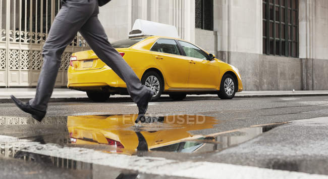 Businessman crossing city street — Stock Photo