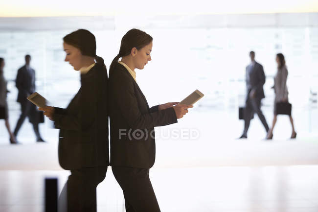 Бізнес-леді, використовуючи цифровий планшет у вестибюлі в сучасному офісі — стокове фото