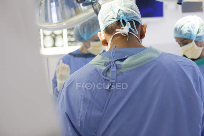 Cirujanos trabajando en quirófano moderno - foto de stock