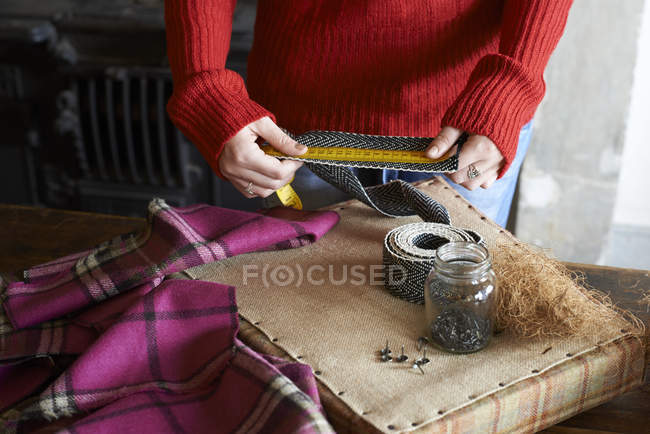 Mulher medindo estofos teia — Fotografia de Stock