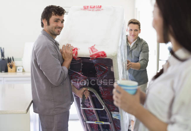 Workers delivering appliance in kitchen — Stock Photo