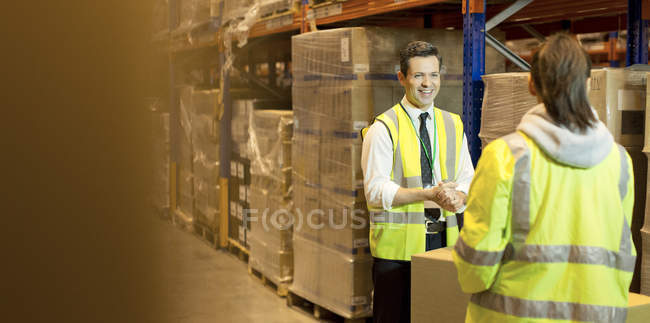 Trabajadores hablando en almacén - foto de stock