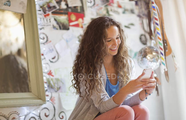 Женщина с мобильным телефоном в спальне — стоковое фото