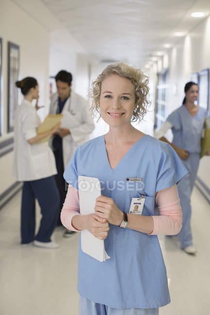 Portrait of smiling nurse in hospital corridor — Stock Photo