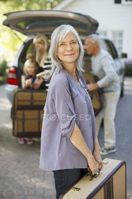 Женщина с чемоданом в багажник — стоковое фото