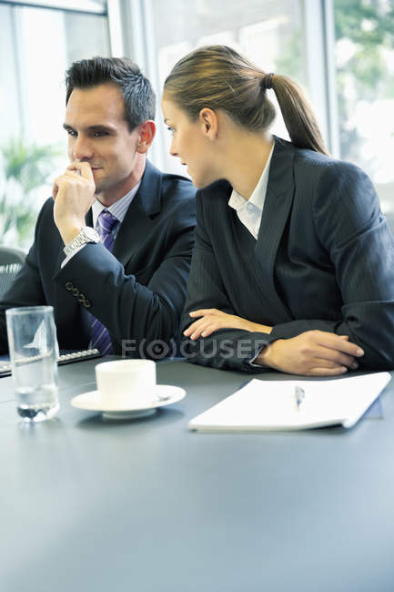 Uomo d'affari e donna d'affari parlare in riunione presso l'ufficio moderno — Foto stock