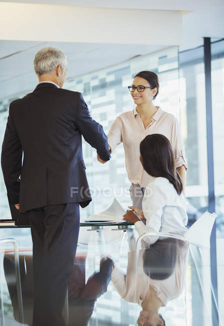 Gente de negocios dando la mano en el edificio de oficinas - foto de stock