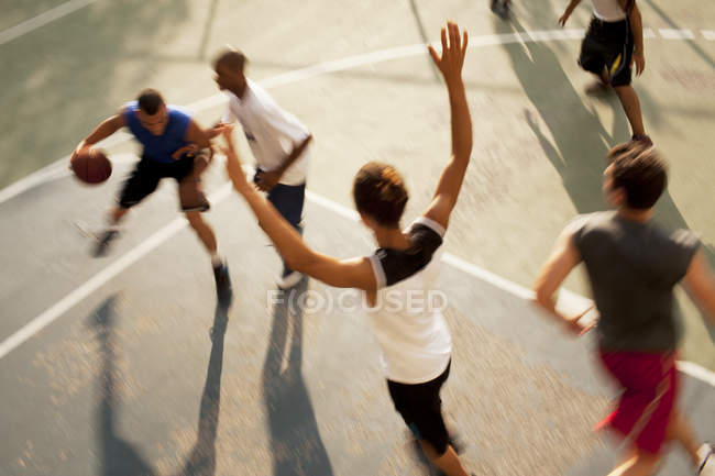 Männer spielen Basketball auf städtischem Platz — Stockfoto