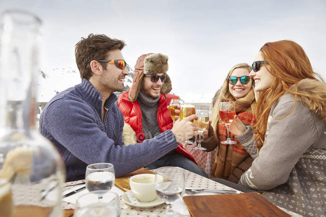 Friends celebrating with drinks in the snow — Stock Photo