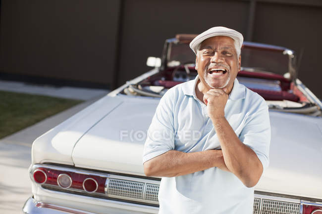 Мужчина постарше улыбается с кабриолетом — стоковое фото