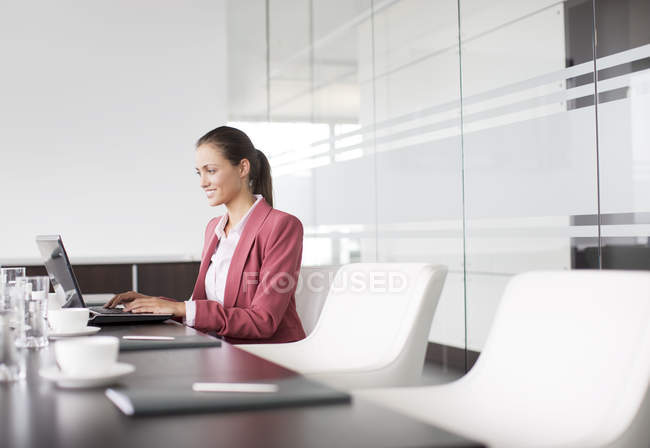 Бізнес-леді, що працює за столом переговорів в сучасному офісі — стокове фото