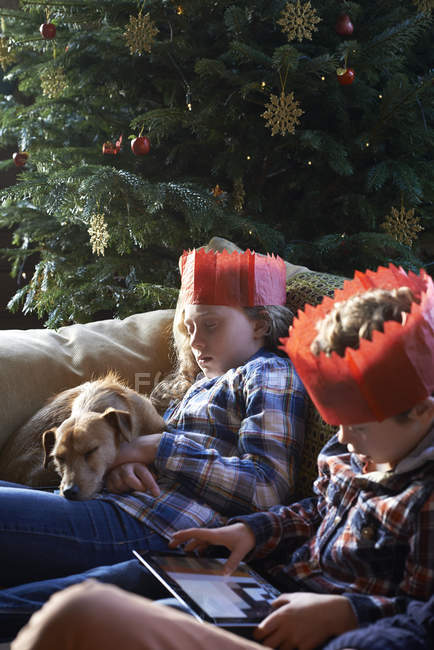Діти в папір коронки розслабляючий на дивані — стокове фото
