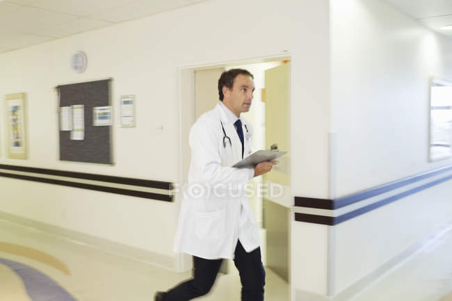 Doctor corriendo en el moderno pasillo del hospital - foto de stock