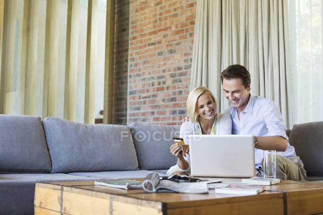 Couple shopping en ligne sur canapé — Photo de stock