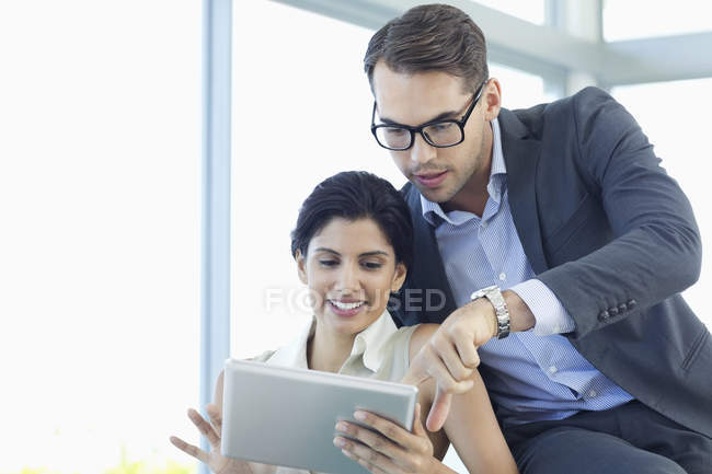 Business people using tablet computer on sofa at modern office — Stock Photo