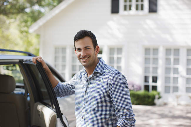 Homme souriant ouvrant la porte de la voiture — Photo de stock