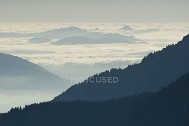 Silhouette of mountainside with clouds — Stock Photo