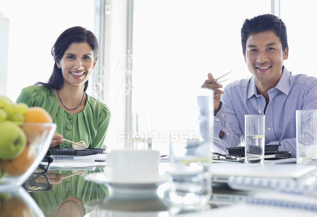 Gente de negocios sonriendo en la reunión en la oficina moderna - foto de stock