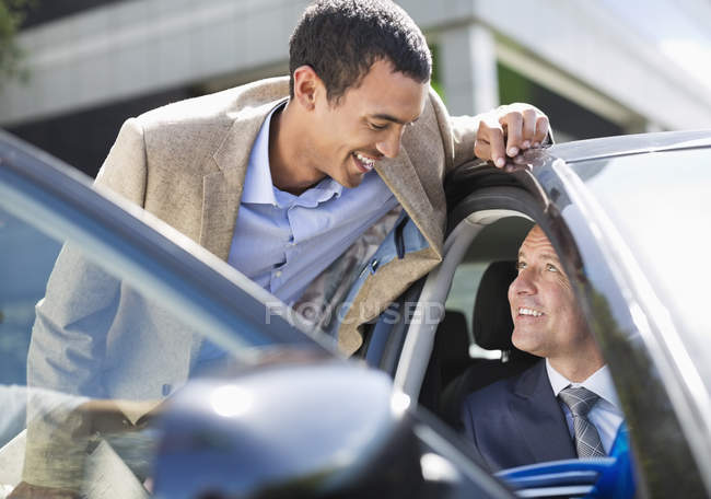 Zwei erfolgreiche Geschäftsleute reden im Auto — Stockfoto