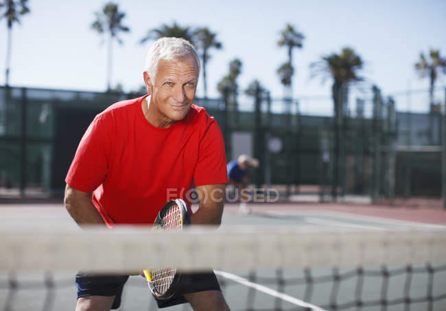 Homem mais velho jogando tênis na quadra — Fotografia de Stock