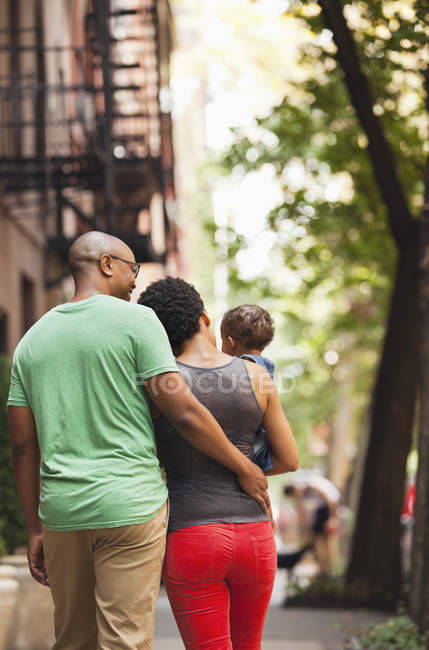 Семья, идущая вместе по городской улице — стоковое фото