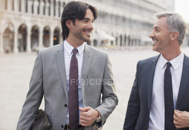 Улыбающиеся бизнесмены разговаривают на площади Святого Марка в Венеции — стоковое фото