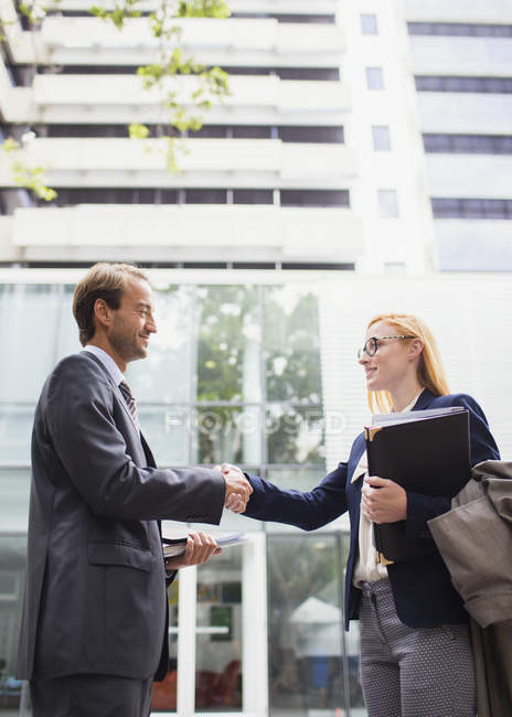 Business people shaking hands outside of office building — Stock Photo