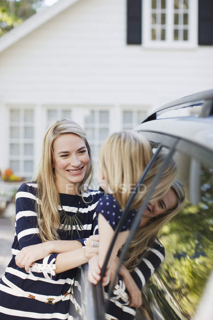Madre hablando con su hija en la ventana del coche - foto de stock