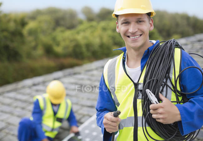 Hábil trabalhador caucasiano sorrindo no telhado — Fotografia de Stock