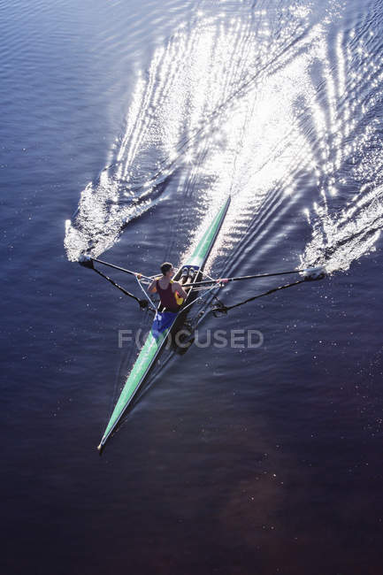 Man rowing scull on lake — Stock Photo