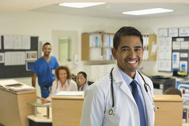 Médico sonriendo en el moderno pasillo del hospital - foto de stock