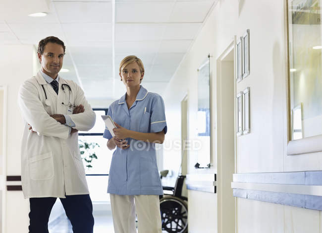 Doctor and nurse standing in hospital hallway — Stock Photo