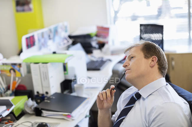 Uomo d'affari che pensa alla scrivania presso l'ufficio moderno — Foto stock