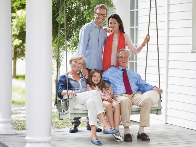 Familie lächelt gemeinsam auf Veranda — Stockfoto