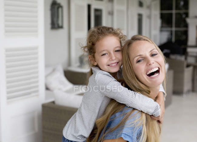 Glückliche Mutter und Tochter spielen auf der Veranda — Stockfoto