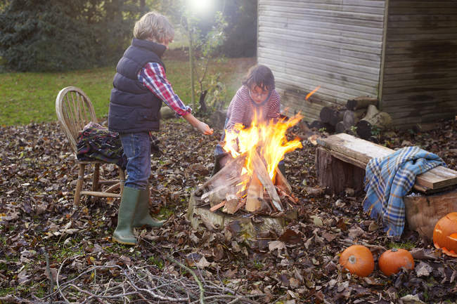 Children building bonfire at backyard — Stock Photo