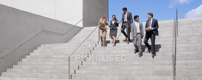 Les gens d'affaires parlent et descendent les escaliers urbains — Photo de stock