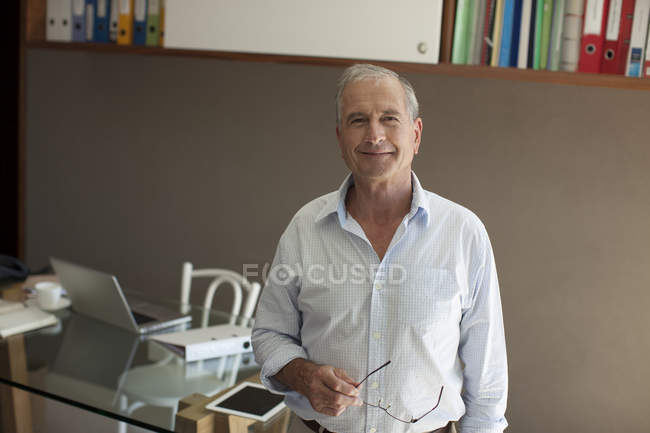 Homme plus âgé souriant dans le bureau — Photo de stock