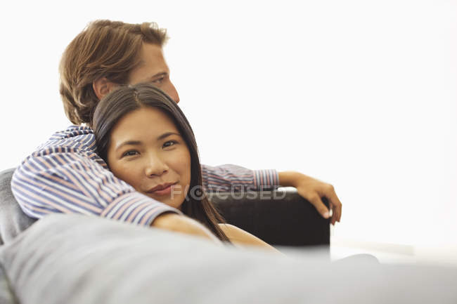 Junges attraktives lächelndes Paar entspannt auf dem Sofa — Stockfoto