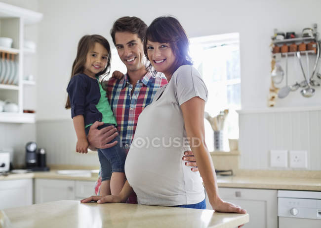 Família sorrindo juntos na cozinha — Fotografia de Stock