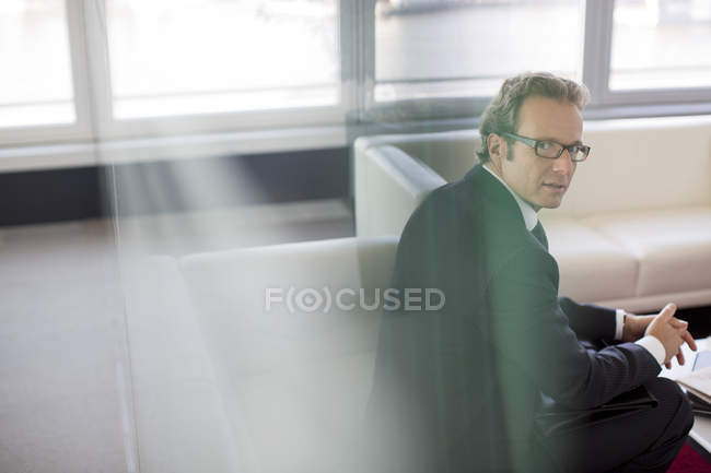 Geschäftsmann sitzt im modernen Büro-Lobby-Bereich — Stockfoto
