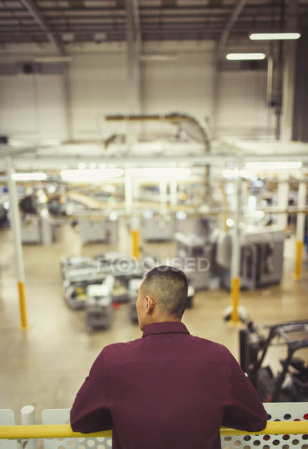 Supervisor on platform looking out over factory — Stock Photo