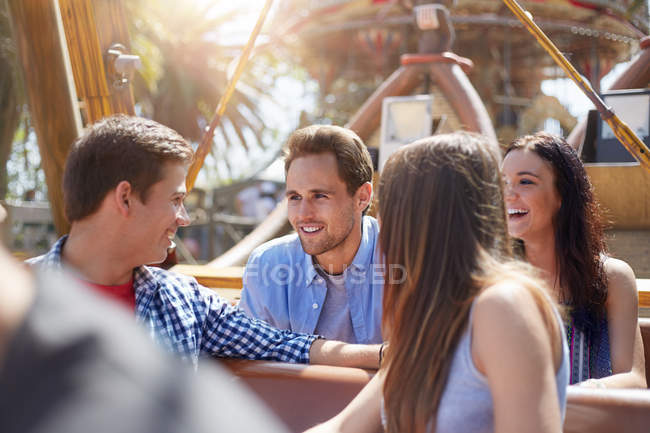 Lächelnde Freunde unterhalten sich auf Vergnügungspark-Fahrt — Stockfoto