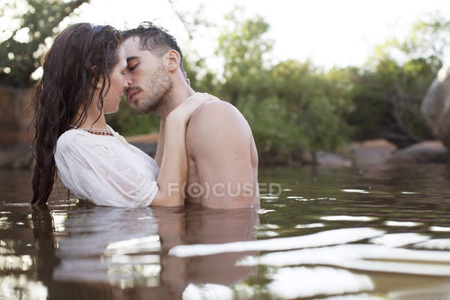 Coppia baciare nel fiume durante il giorno — Foto stock