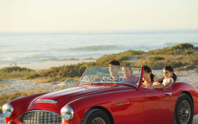 Family in convertible on beach — Stock Photo