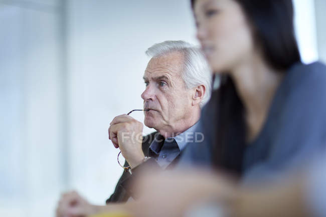 Фокусований старший бізнесмен слухає на зустрічі — стокове фото
